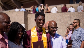 Black student celebrating graduation with family