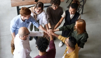 Diverse coworkers putting hands together in a circle