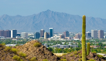 The Phoenix Arizona skyline with desert mountains in the foreground and background