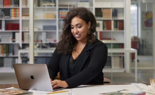 Black woman sitting at desk on laptop
