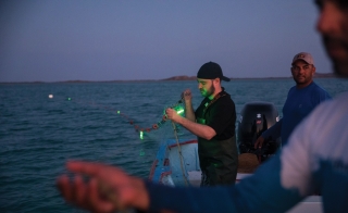 ASU marine biologist Jesse Senko using illuminated nets on a boat in the ocean.