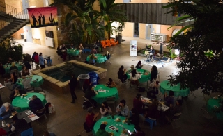 Aerial shot of Local to Global Justice event showing people sitting at tables inside an event hall.