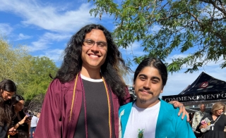 ASU grad George Ramos (left) wears his graduation regalia while standing next to current ASU student Jesus Ledezma.