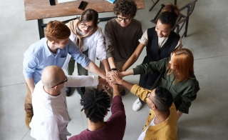 Diverse coworkers putting hands together in a circle