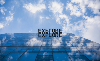 Photo of the "explore" sign at the top of Coor Hall on ASU's Tempe campus.