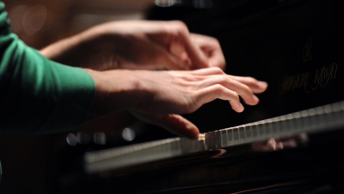student hands playing piano