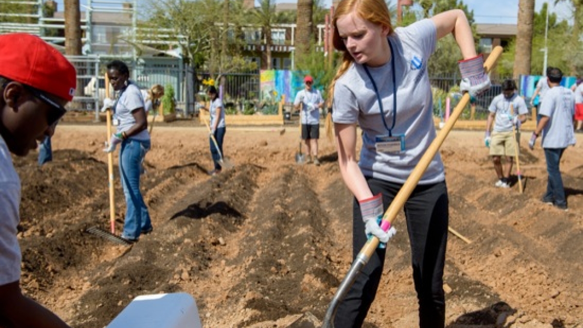 female student digging at a work site during the CGIU day of service