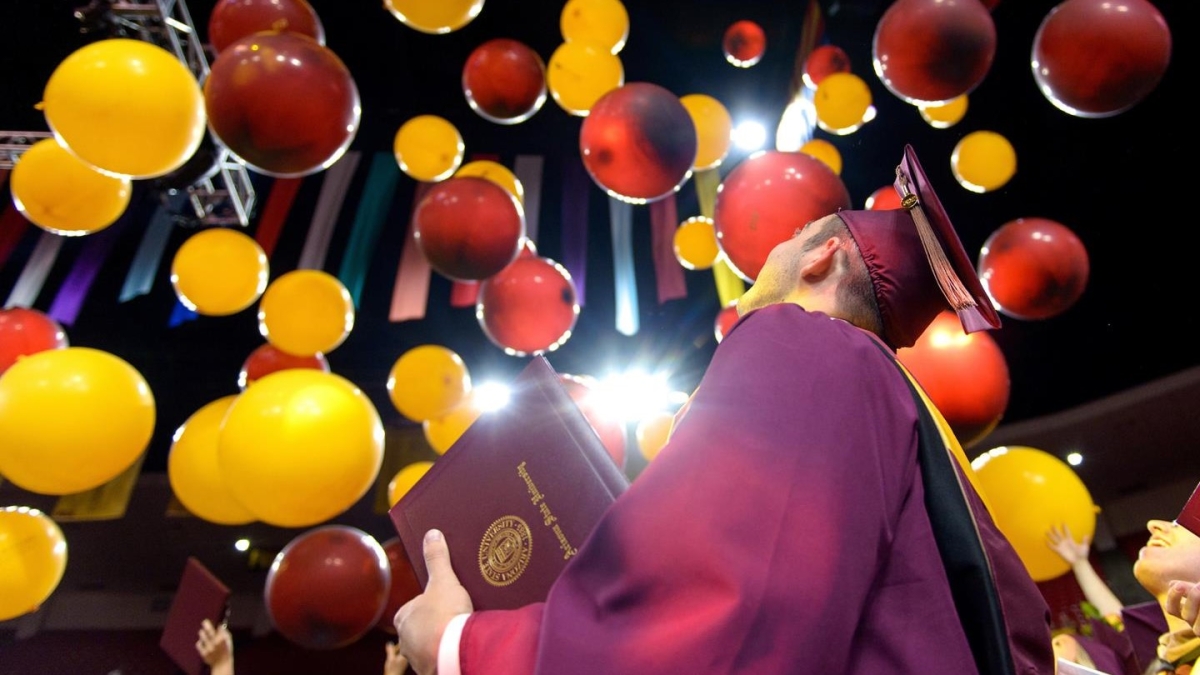 graduate looking at graduation balloons launched during convocation
