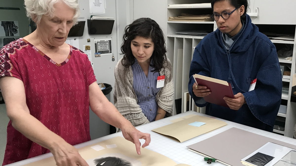ASU-LACMA Fellows Ariana Enriquez and Matthew Villar Miranda work with Janice Schopfer, senior paper conservator in LACMA's Conservation Lab.
