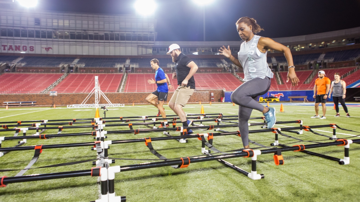people running through an obstacle course in a stadium