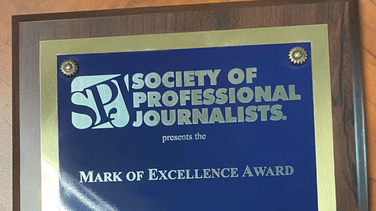 Colse-up of an award/plaque that reads "Society of Professional Journalists presents the Mark of Excellence Award."
