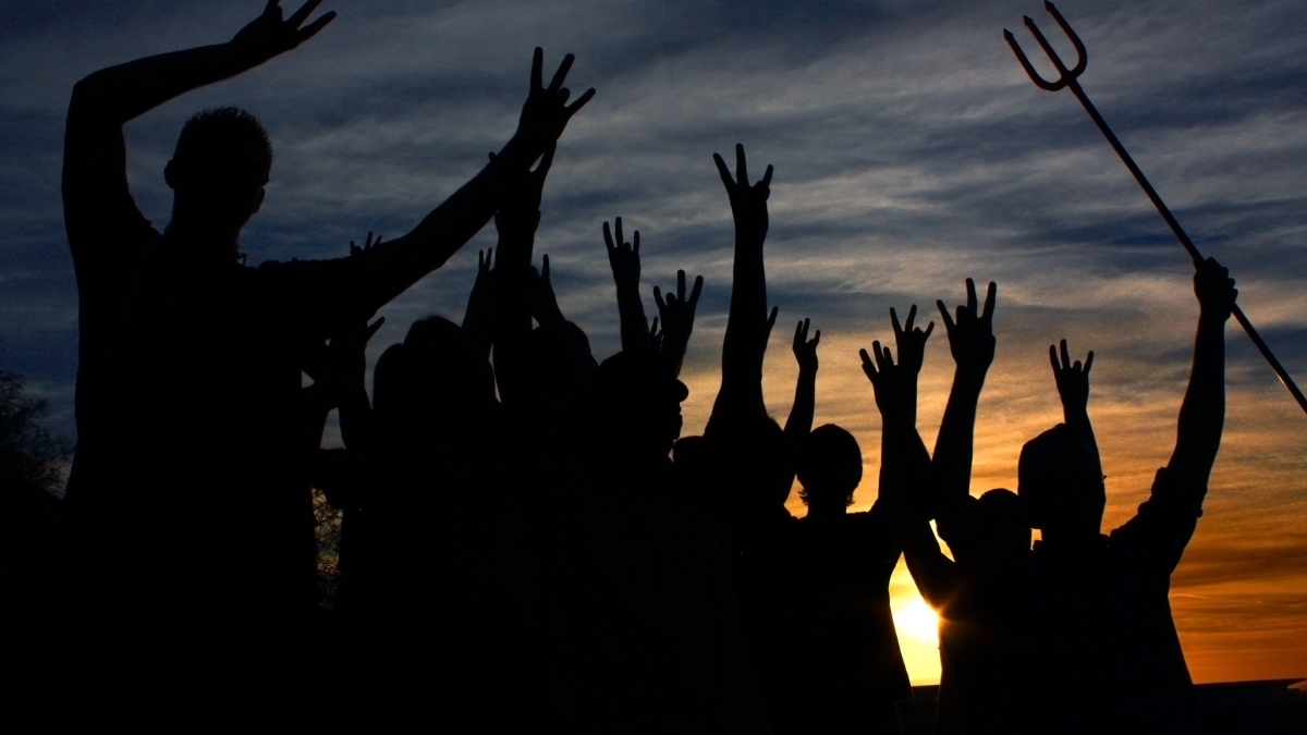 students flashing the pitchfork against a sunset