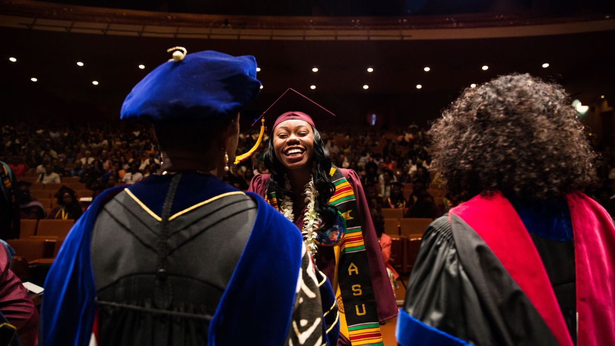 Graduates make their way through shaking hands of faculty during the Black and African Convocation at ASU Gammage on Thursday, May 12, 2016.