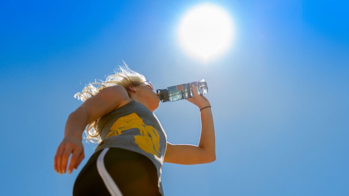 Person drinking water in the sun 