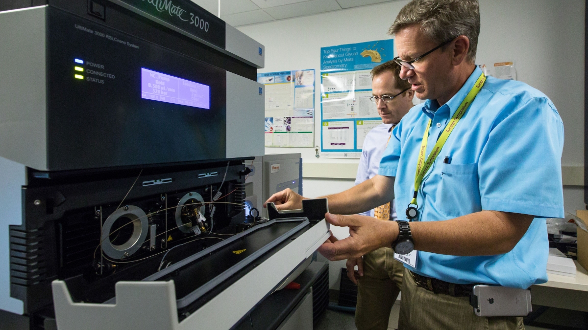 Medical researchers work with a mass spectrometer in a lab