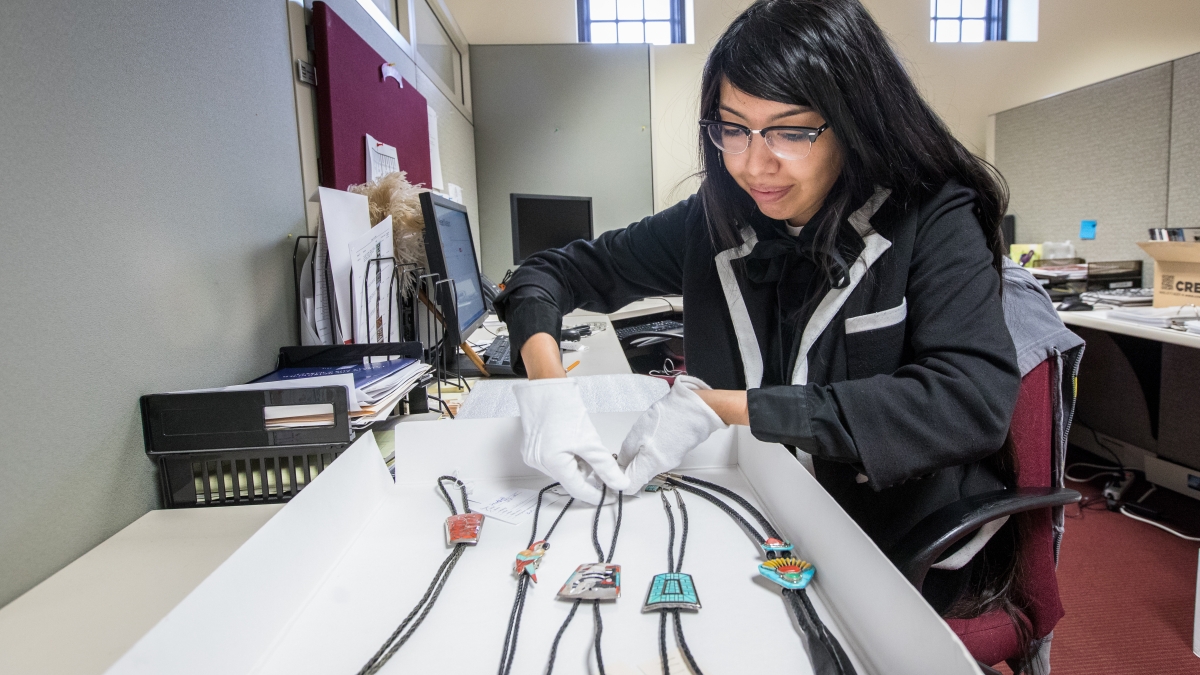 ASU alum and Mellon Fellow Kayannon George working with bolo ties at Heard Museum