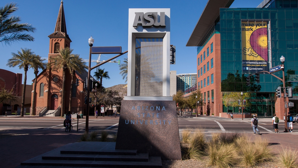 An ASU sign shown with the Fulton Center building and a church behind it