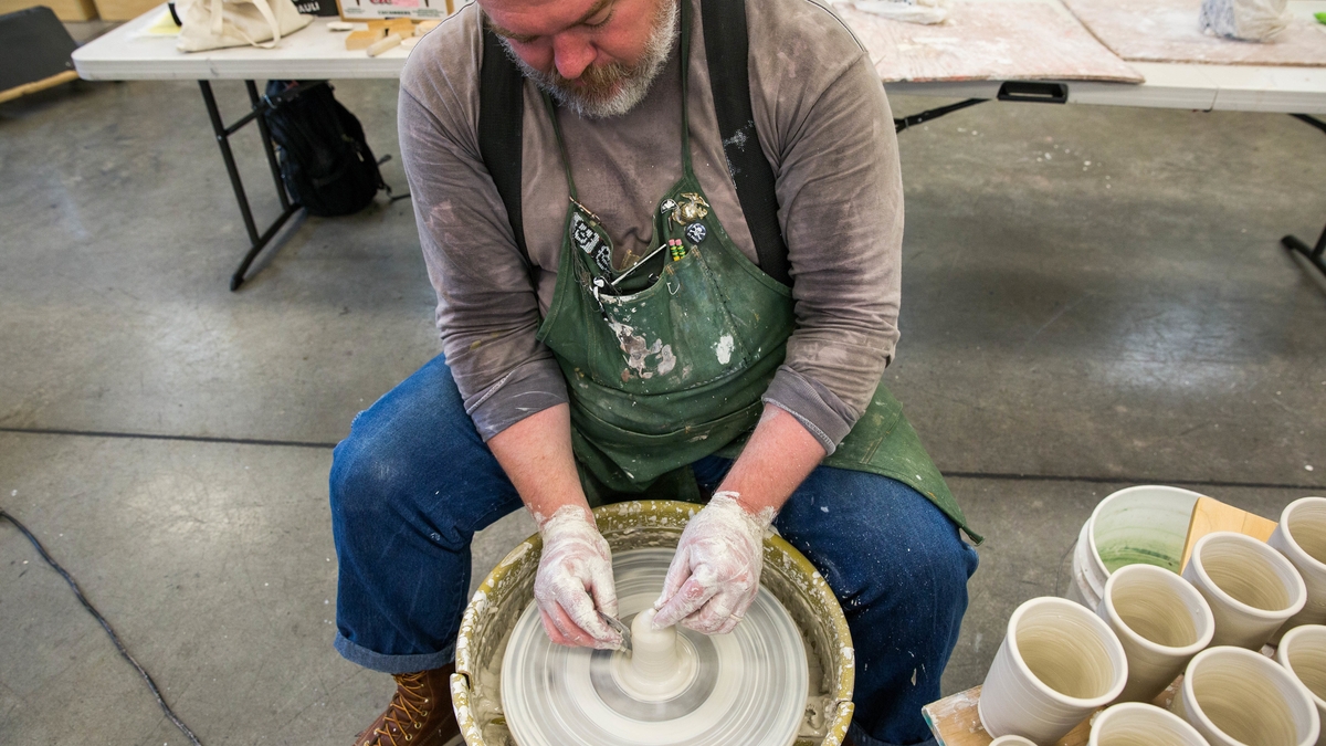 Ehren Tool shapes a ceramic cup