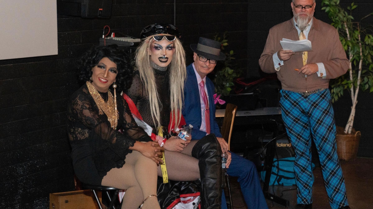 drag queens on stage with moderator at event