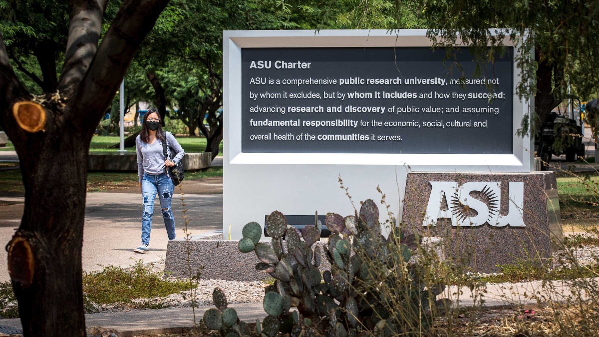 A student walks past the ASU charter sign