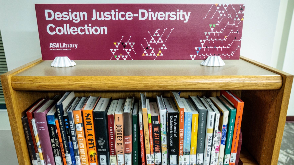 Books in a shelf under a sign that reads "Design Justice-Diversity Collection."