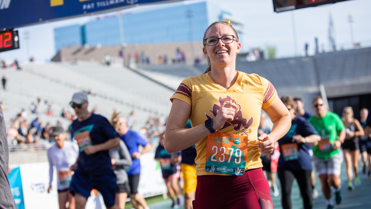 woman wearing Sparky T-shirt crosses race finish line