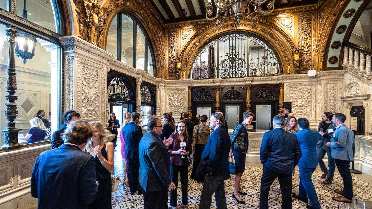 A crowd of people mingle in the ornate lobby of the Herald Examiner building in LA