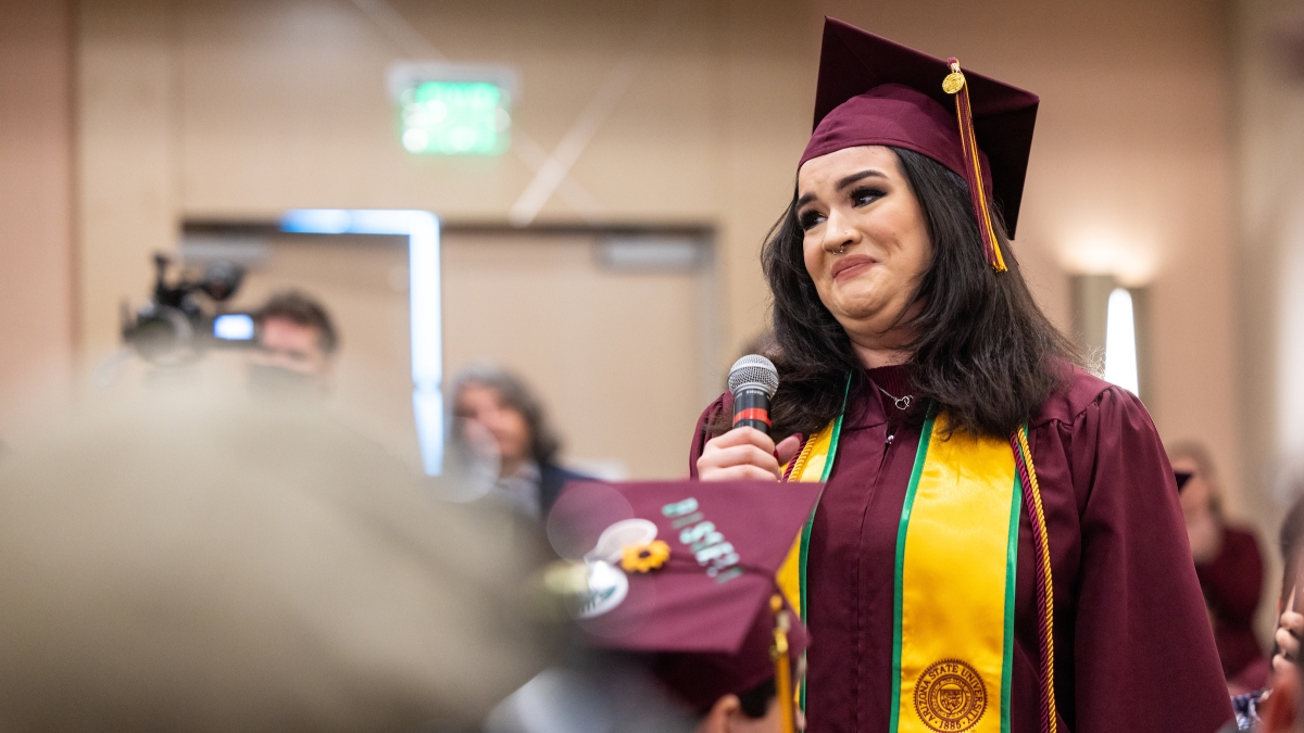 Graduate tearfully talks to group at event