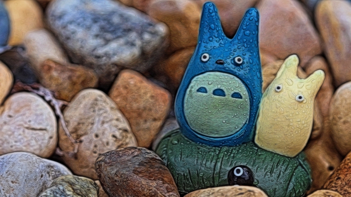 Depiction of Studio Ghibli film character Totoro set against backdrop of colorful rocks.