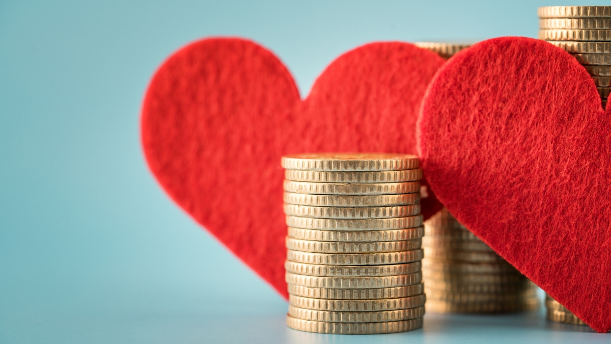 Close-up view of red, felt hearts and stacks of coins.