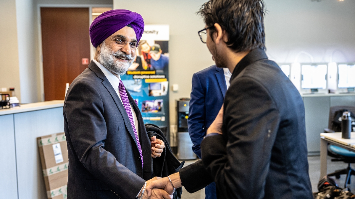 Indian ambassador shaking hands with student