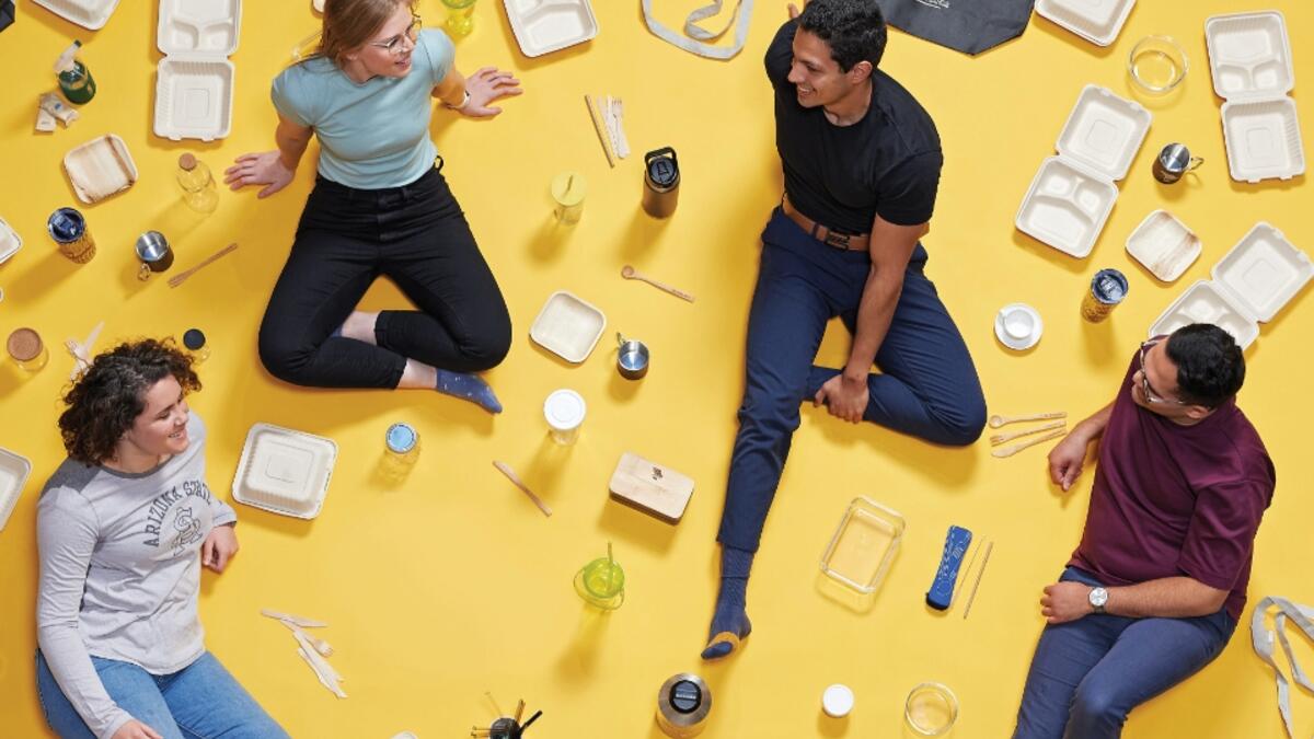 People sitting on yellow-colored floor with plastic items around them