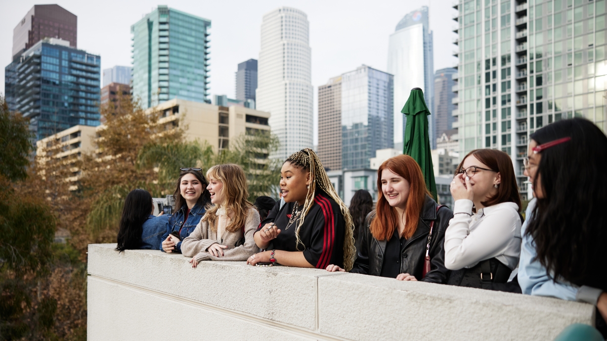 ASU FIDM students looking over downtown Los Angeles from the balcony of the ASU California Center Grand building.