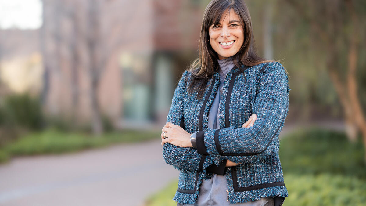 Portrait of woman with long brown hair and blue jacket taken outside on ASU Tempe campus