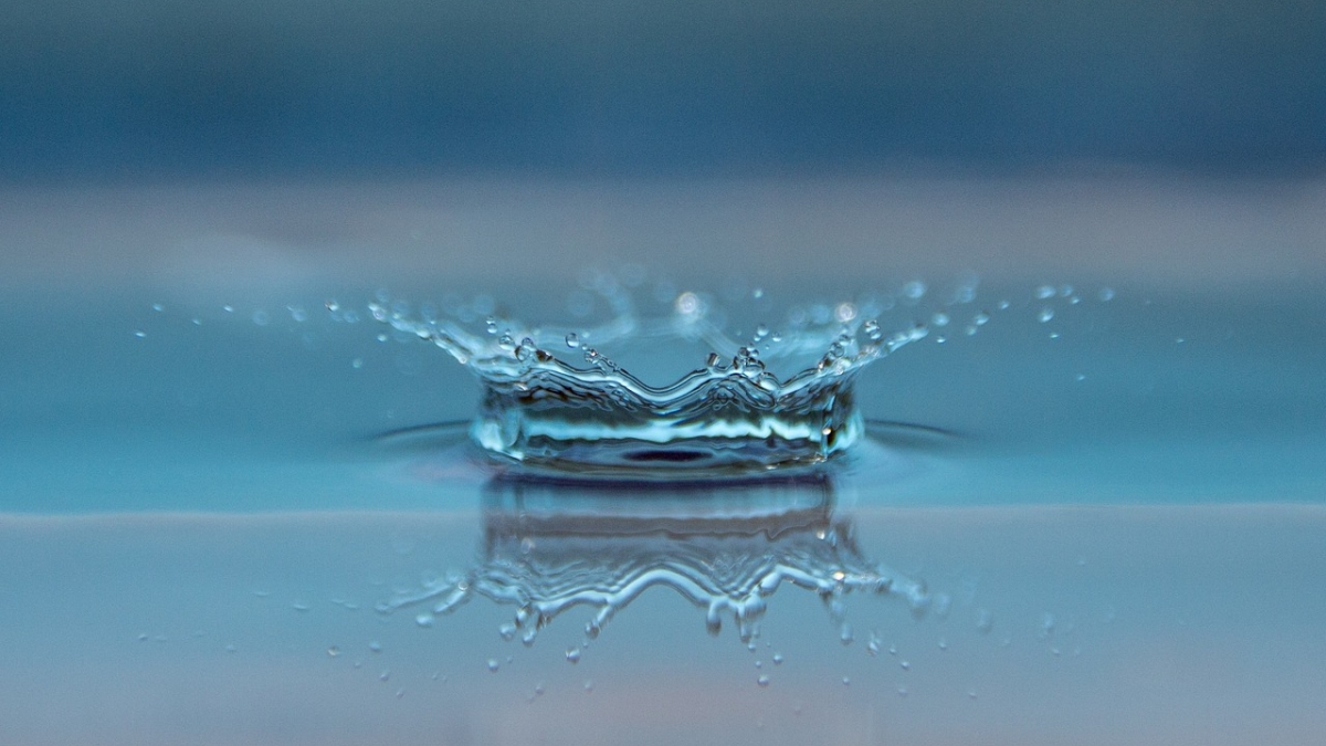 Close-up image of a water drop splashing into water