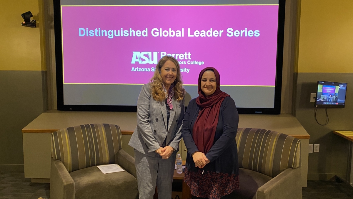 Rangina Hamidi and Kristen Hermann standing in front of a screen that reads "Distinguished Global Leader Series"