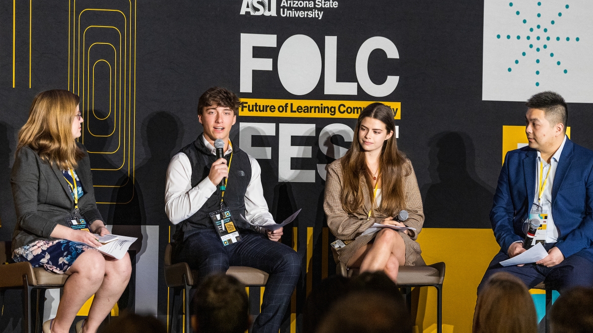 Four people sit on a stage with a FOLC Fest sign behind them