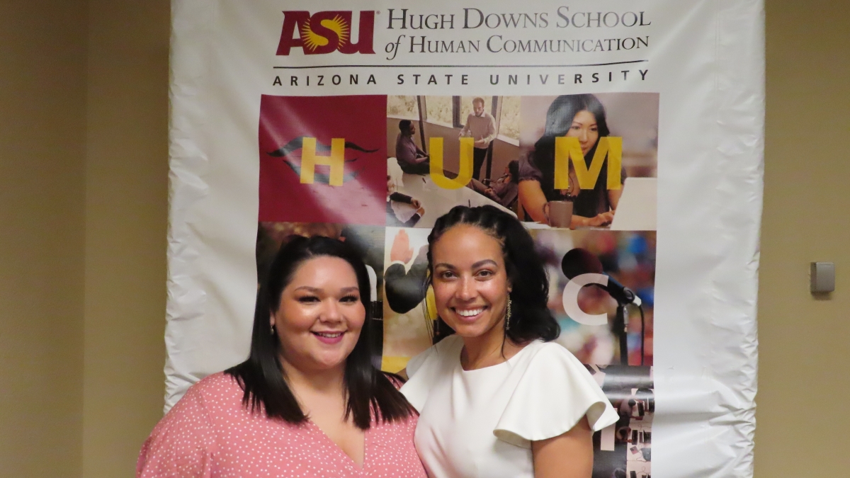 Two women posing in front of ASU backdrop