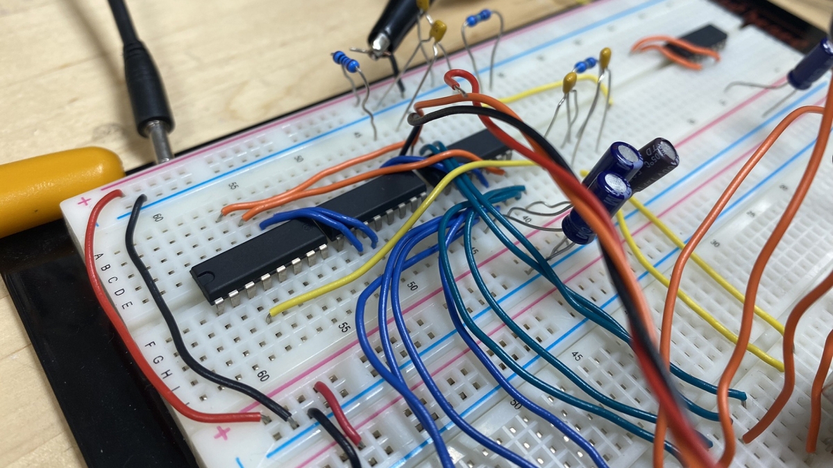 Close-up view of a circuit board with different colored wires running across it.