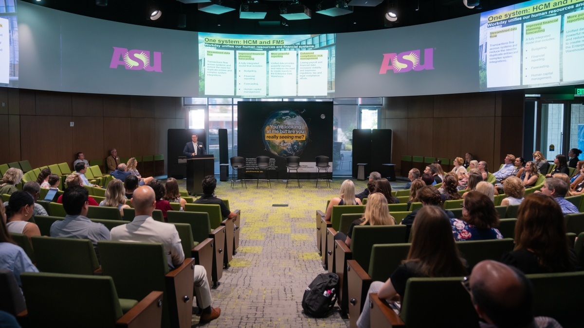 People in an auditorium watch a presentation