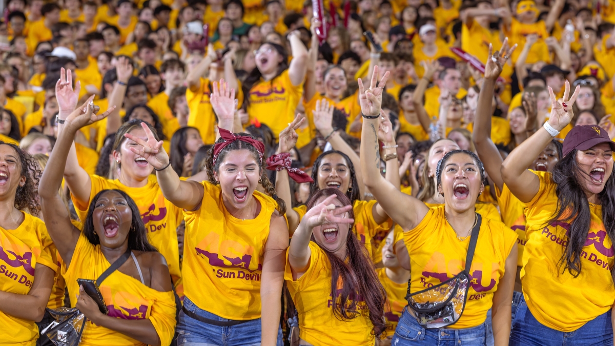 Sea of students wearing gold t-shirts cheer during ASU event