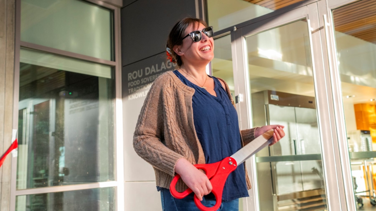 Portrait of Kaitlin Reed holding oversized prop scissors 