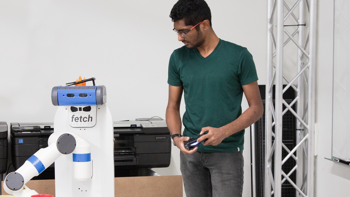 Jayesh Nagpal holds a controller to help train a robot.