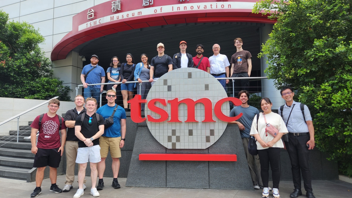 A large group posing around a TSMC sign in Taiwan.