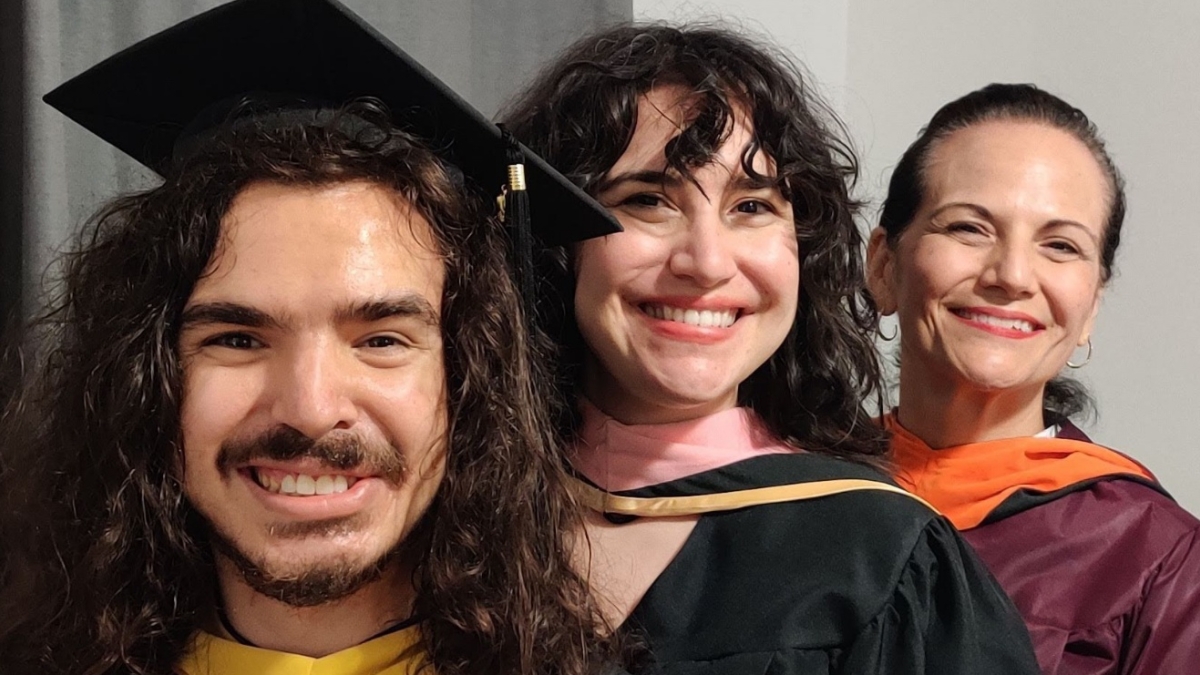 Three people in graduation gowns