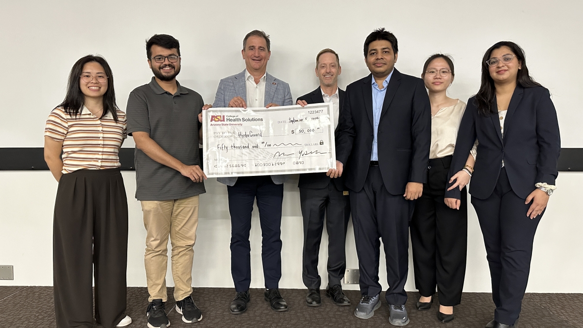 Group of people pose with a large check.