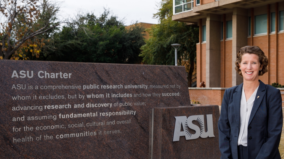 Sally Morton standing in front of ASU charter sign on Tempe campus