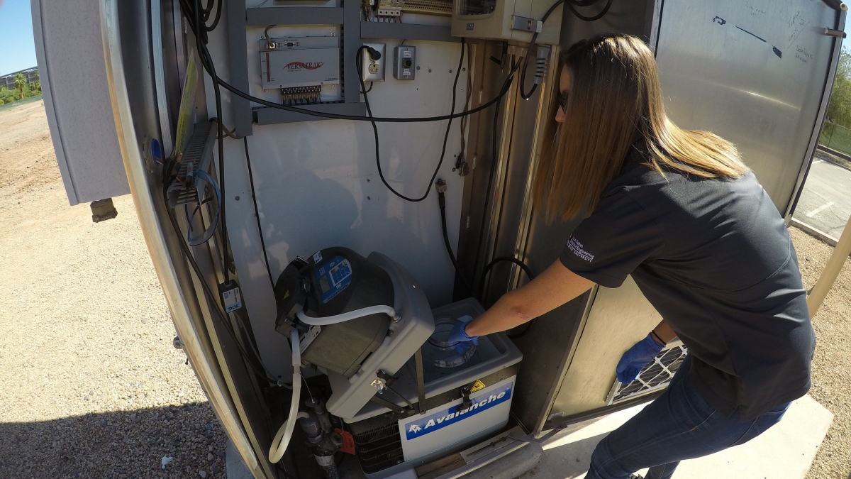 ASU PhD candidate Erin M. Driver examines a water sampling station