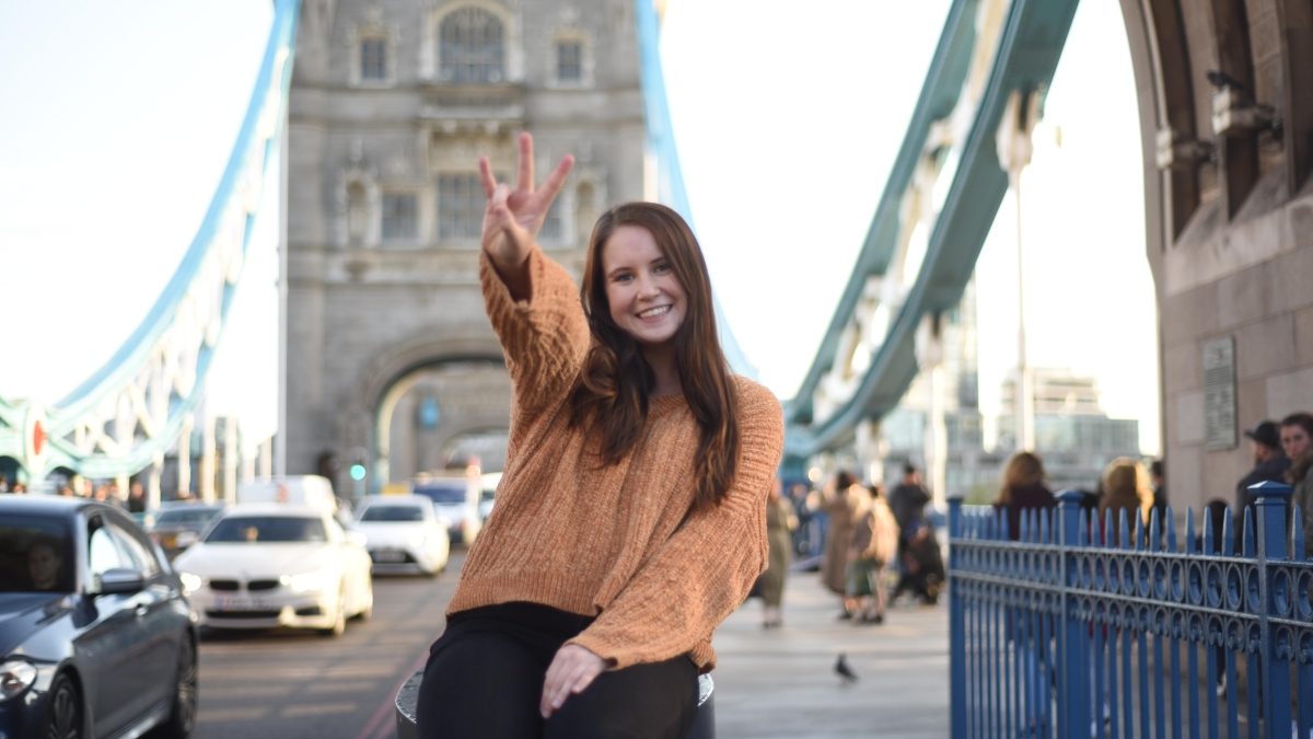 ASU student smiling holding up a pitchfork on the London Bridge
