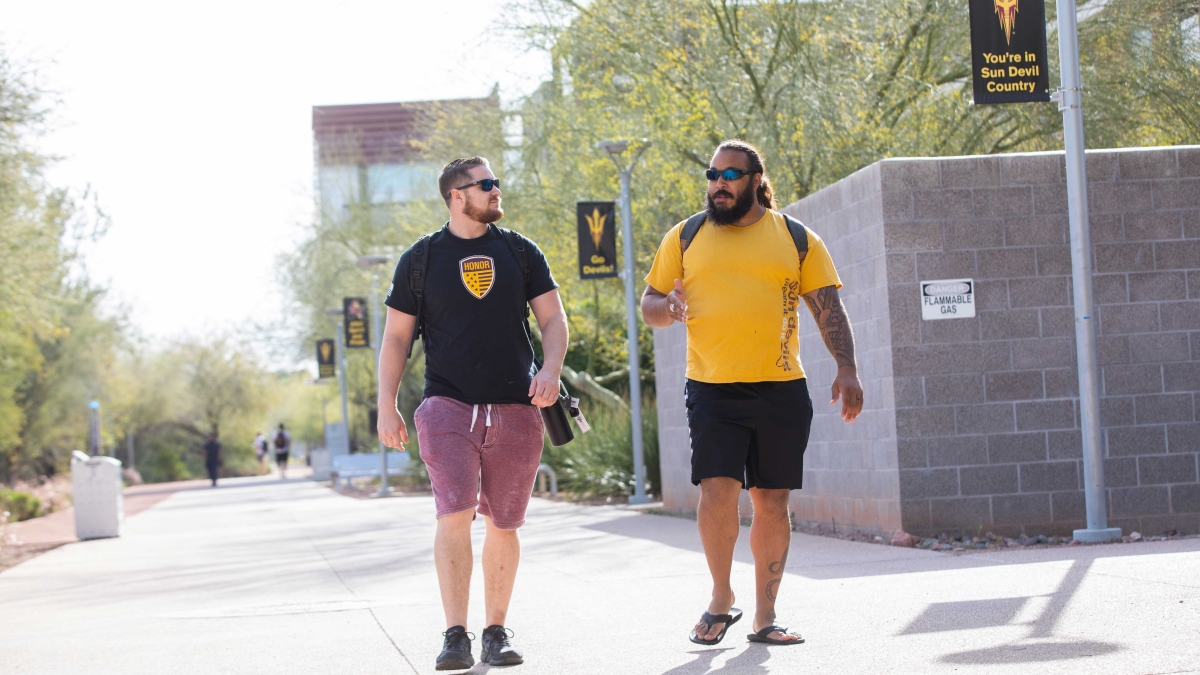 Two student veterans walking and talking on the ASU campus.